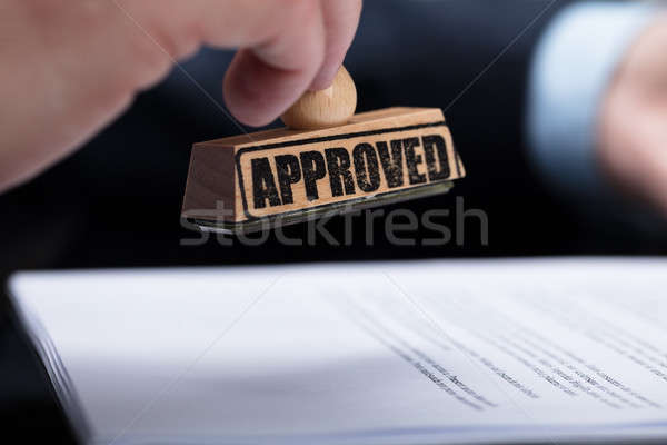 Stock photo: Businessperson Stamping On Approved Contract Form