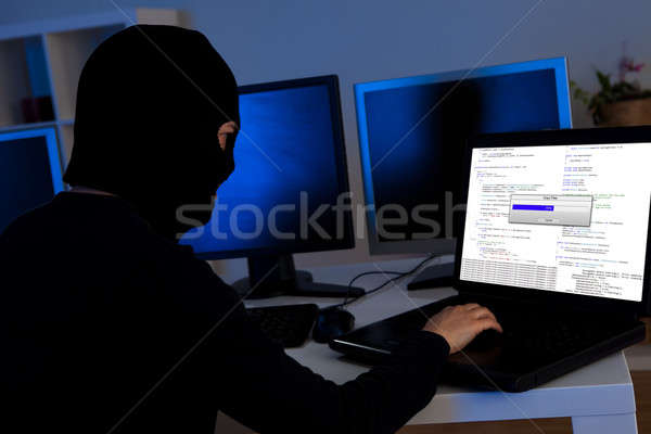 Hacker downloading information off a computer Stock photo © AndreyPopov