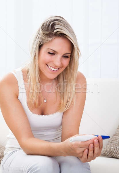 Happy woman looking  at positive pregnancy test Stock photo © AndreyPopov