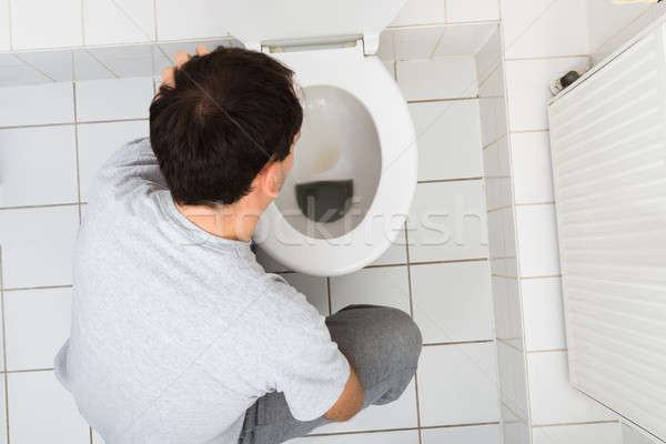 Man Vomiting In Bathroom Stock photo © AndreyPopov