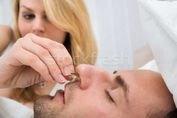 Woman Inserting Nose Clip Device Into Man Nose Stock photo © AndreyPopov