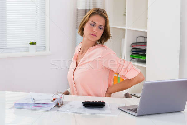 Mulher jovem sofrimento dor nas costas imposto secretária computador Foto stock © AndreyPopov