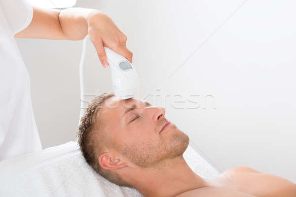 Young Man Receiving Laser Hair Removal Treatment Stock photo © AndreyPopov