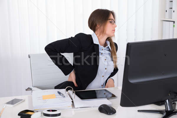 Imprenditrice sofferenza mal di schiena seduta sedia ufficio Foto d'archivio © AndreyPopov