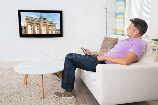 成熟的男人 坐在 榻 看電視 家 男子 商業照片 © AndreyPopov