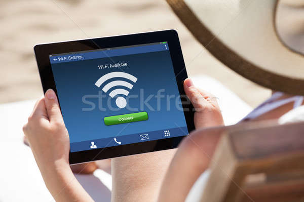 Woman Holding Digital Tablet At Beach Stock photo © AndreyPopov