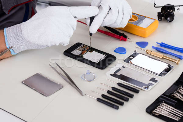 Persoană surubelnita repara spart telefon Imagine de stoc © AndreyPopov