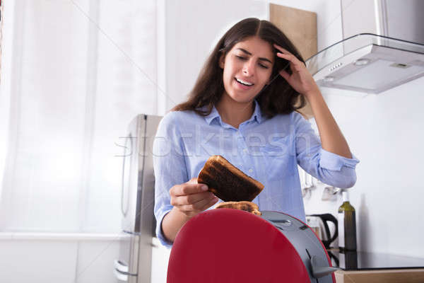 Unhappy Woman Holding Burnt Toast Stock photo © AndreyPopov
