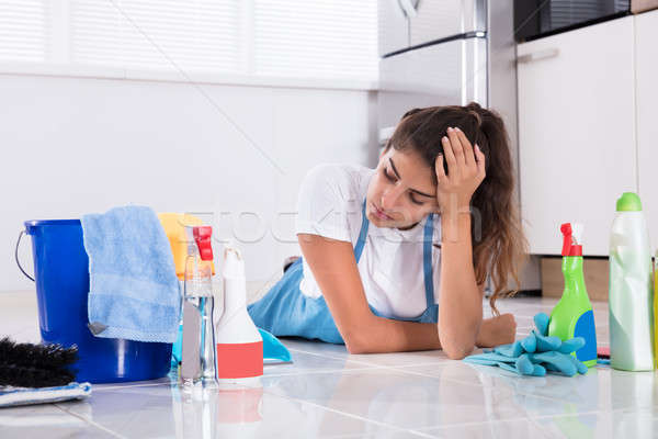 Woman Lying On Kitchen Floor And Looking At Cleaning Products Stock photo © AndreyPopov