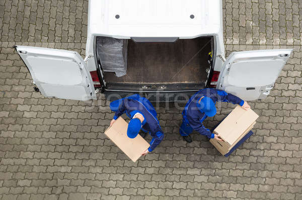 Two Delivery Men Unloading Cardboard Box From Truck Stock photo © AndreyPopov