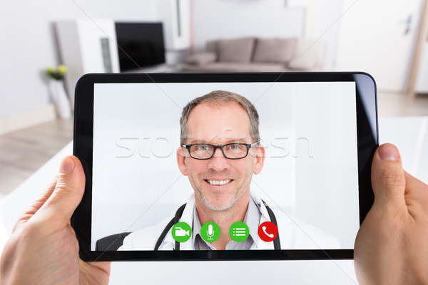 Person Video Conferencing With Doctor On Digital Tablet Stock photo © AndreyPopov