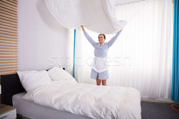 Házvezetőnő ágy mosolyog fiatal női hotelszoba Stock fotó © AndreyPopov