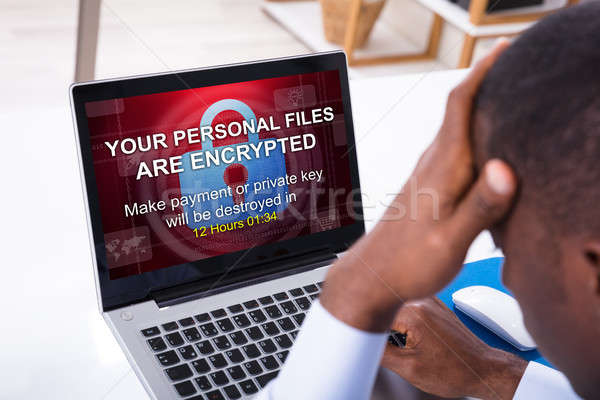 Worried Businessman With Encrypted Text On The Laptop Screen Stock photo © AndreyPopov