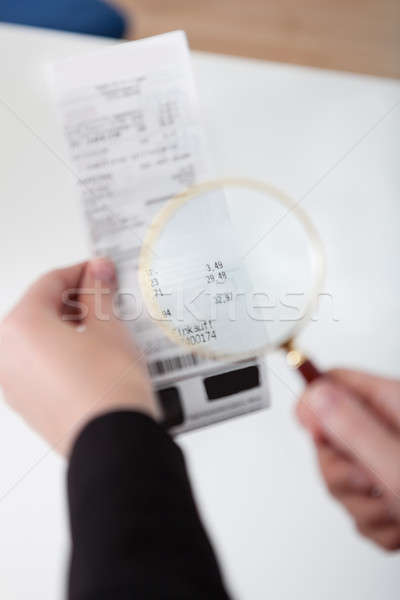 Businesswoman looking at check trough the loupe Stock photo © AndreyPopov