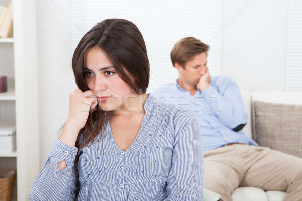 Upset Woman With Man Sitting On Sofa In Background Stock photo © AndreyPopov