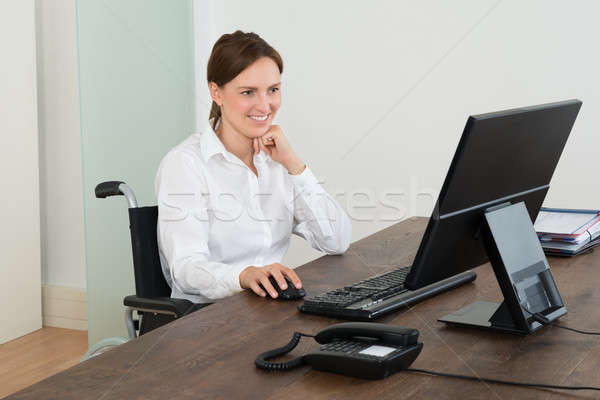 Businesswoman On Wheelchair While Working On Computer Stock photo © AndreyPopov