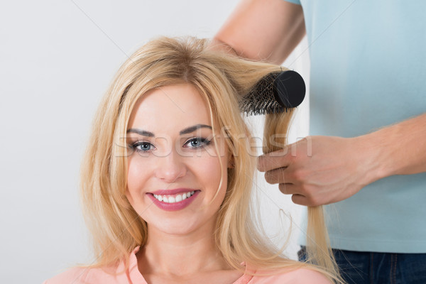 Hairstylist Brushing Woman's Hair At Salon Stock photo © AndreyPopov