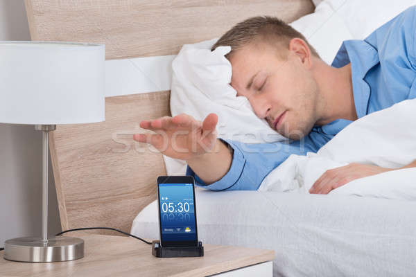 Man Snoozing Alarm On Mobile Phone Screen Stock photo © AndreyPopov