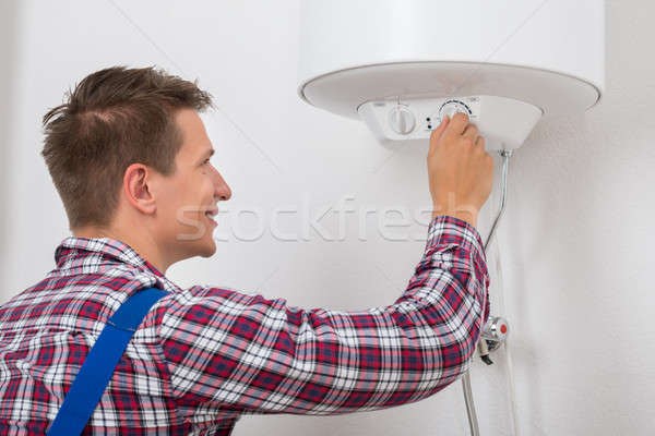Plumber Turning The Knob Of Electric Boiler Stock photo © AndreyPopov