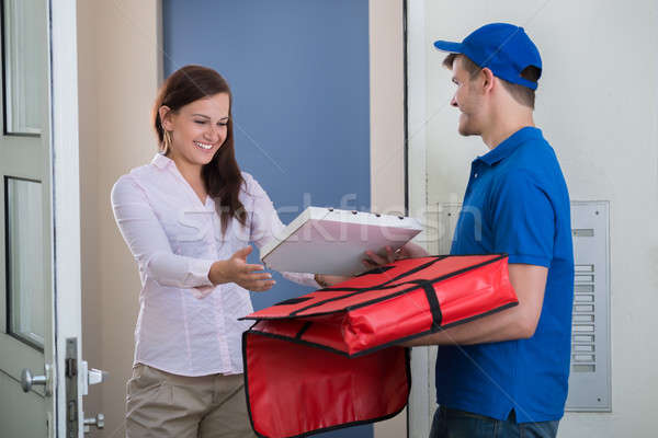Man Delivering Pizza To Young Woman Stock photo © AndreyPopov