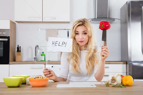 Frustrated Woman Holding Help Flag In Kitchen Stock photo © AndreyPopov