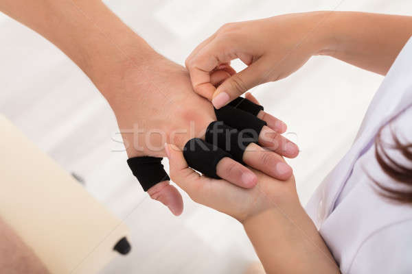 Stock photo: Doctor Putting Finger Protector Sleeve On Man's Finger