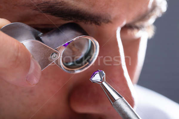 Jeweler Looking At Diamond Through Magnifying Loupe Stock photo © AndreyPopov