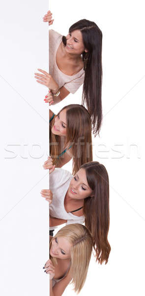 Four women peering at a blank sign Stock photo © AndreyPopov