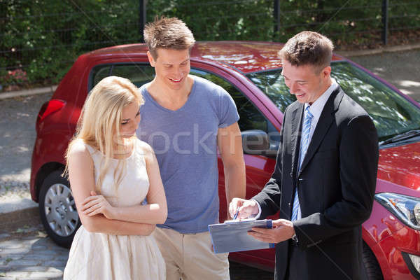 Salesman Showing Contract Paper To Couple By Car Stock photo © AndreyPopov