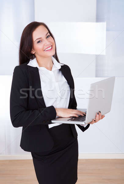 Welldressed Businesswoman Using Laptop In Office Stock photo © AndreyPopov