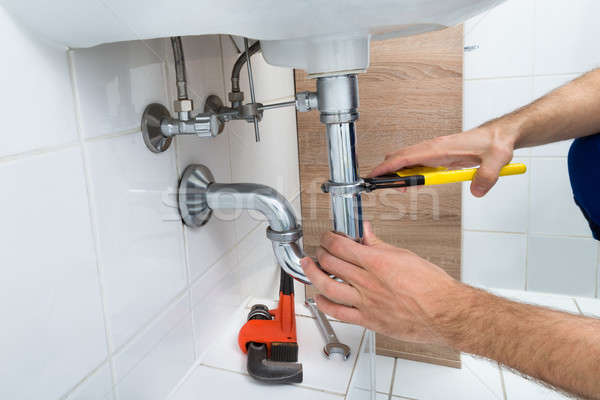 Male Plumber Fixing Sink In Bathroom Stock photo © AndreyPopov