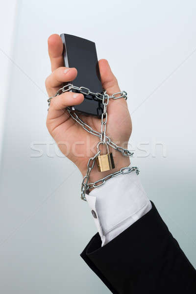 Businessman's Hand Chained With Cellphone Stock photo © AndreyPopov