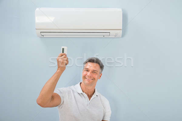 Stock photo: Man Operating Air Conditioner