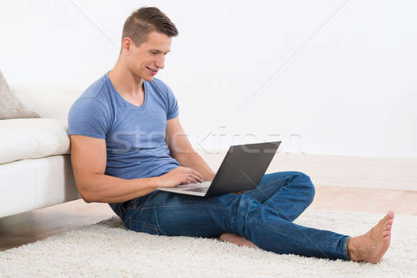 Stock foto: Mann · Laptop · Sitzung · Teppich · jungen · glücklich