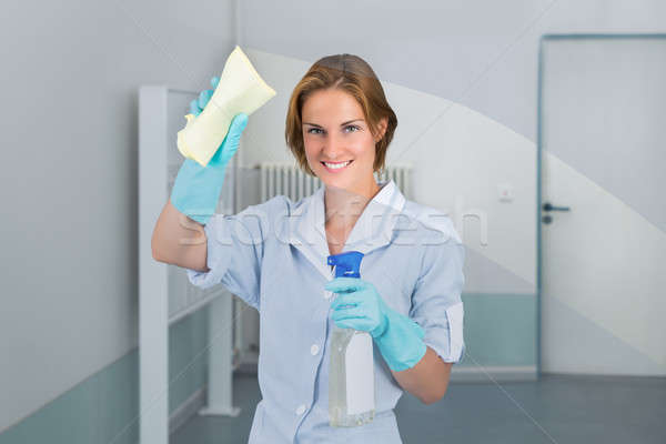 Young Female Maid Wiping Glass Stock photo © AndreyPopov
