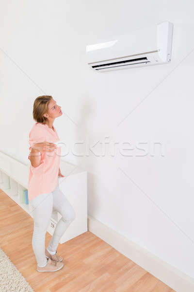 Donna condizionatore d'aria telecomando ragazza muro Foto d'archivio © AndreyPopov