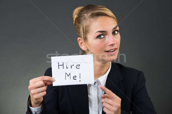 Businesswoman Holding Paper With Hire Me Text Stock photo © AndreyPopov