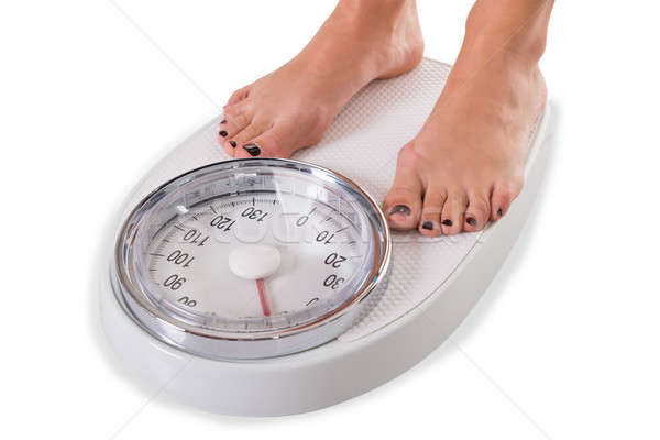 Low Section Of Woman Standing On Weighing Scale Stock photo © AndreyPopov