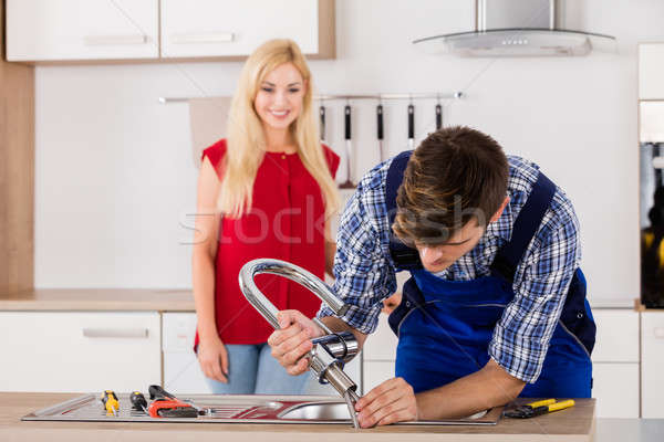 Male Repairman Installing Faucet Of Kitchen Sink Stock photo © AndreyPopov
