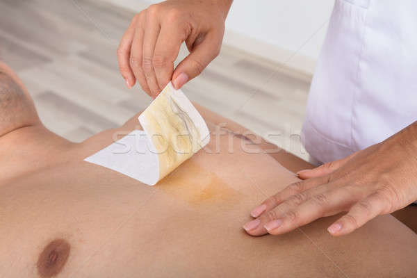 Therapist Waxing Man's Chest Stock photo © AndreyPopov
