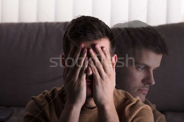 Sad Man Sitting In Front Of Sofa Stock photo © AndreyPopov