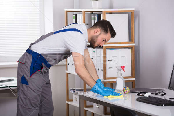 Man Cleaning Desk In Office Stock photo © AndreyPopov