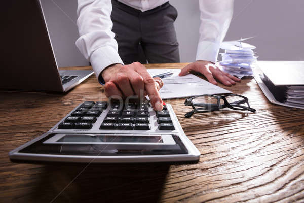 Businessperson Calculating Bill With Calculator Stock photo © AndreyPopov