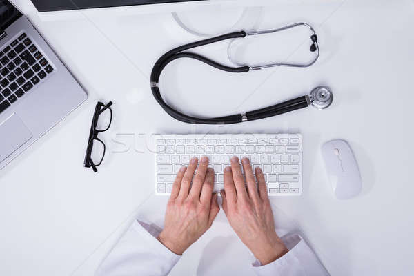 Elevated View Of A Doctor's Hand Typing On Computer Keyboard Stock photo © AndreyPopov