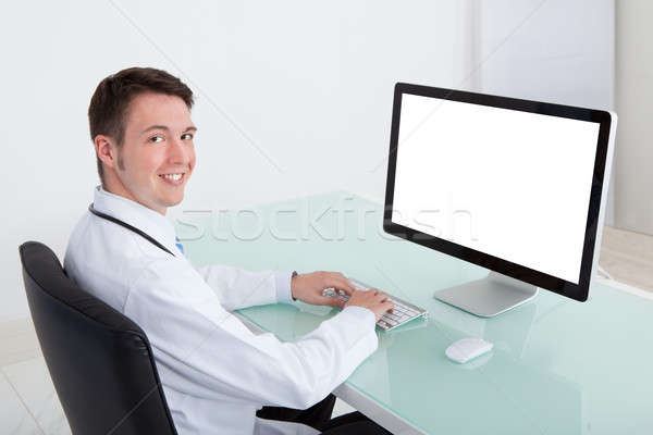 Confident Male Doctor Working On Computer At Desk Stock photo © AndreyPopov