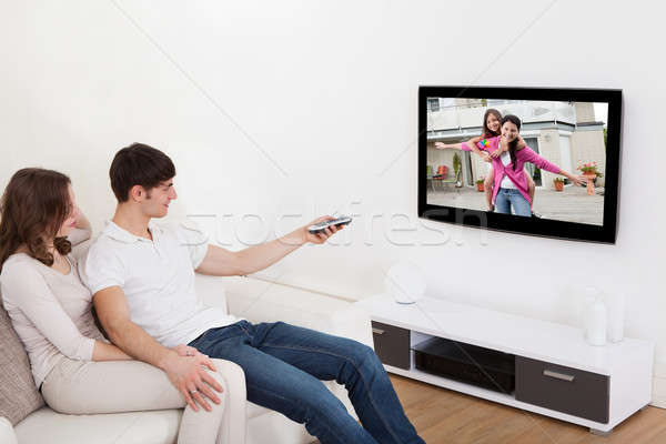 情侶 客廳 看電視 坐在 榻 商業照片 © AndreyPopov