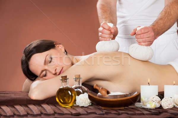 Woman Receiving Massage With Herbal Compress Stamps At Spa Stock photo © AndreyPopov