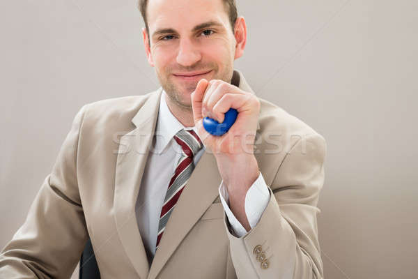 Businessman Squeezing Blue Stressball Stock photo © AndreyPopov