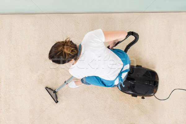 Young Female Janitor Vacuuming Floor Stock photo © AndreyPopov