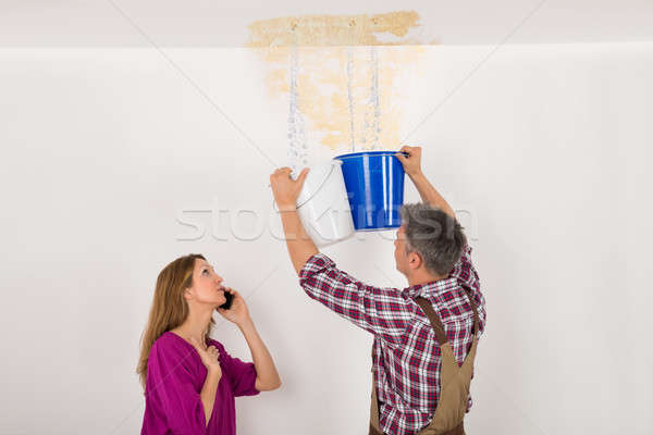 Worker Collecting Water In Bucket From Ceiling Stock photo © AndreyPopov